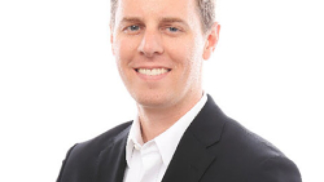 A man smiling for a portrait photo.