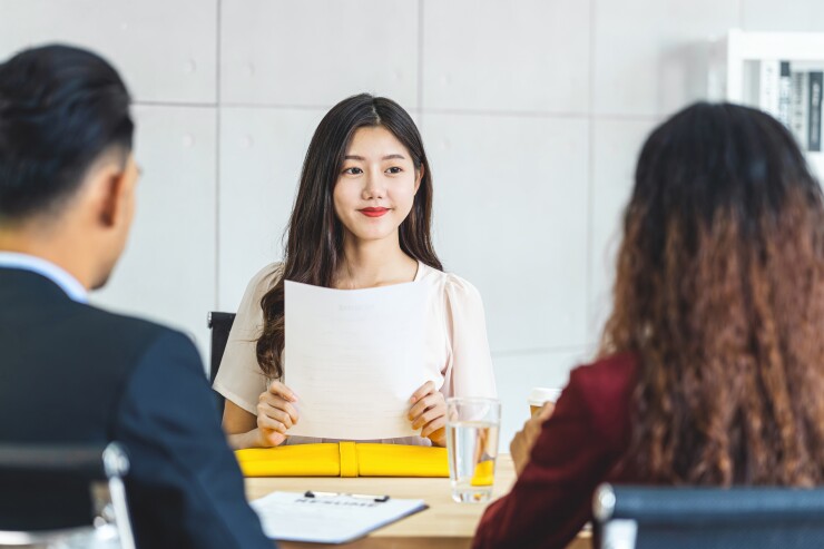 Woman sitting in a job interview holding her resume