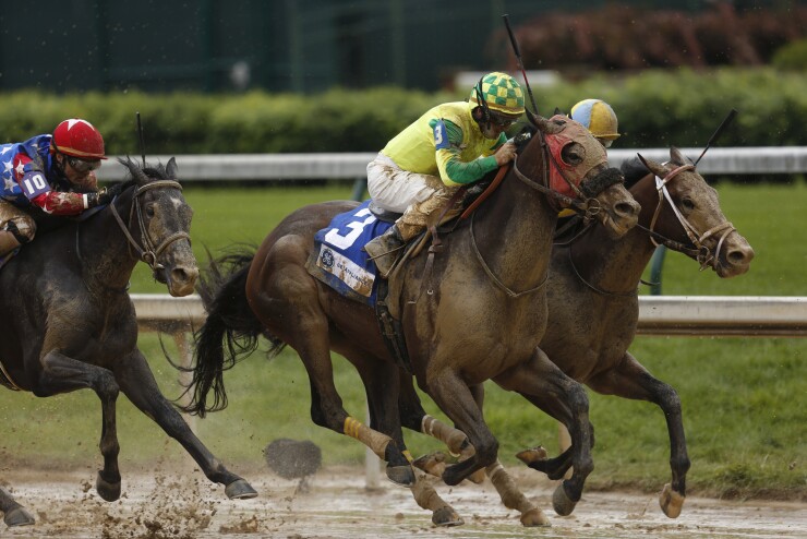 Jockeys ride thoroughbred racehorses during an afternoon race before the 143rd running of the Kentucky Derby at Churchill Downs in Louisville, Kentucky.