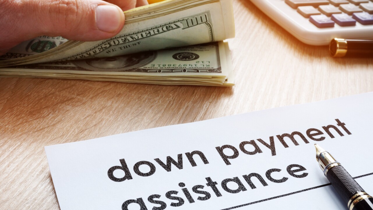 Down payment assistance form and dollar banknotes.