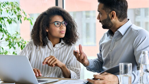 Manager talking with employees, two employees talking