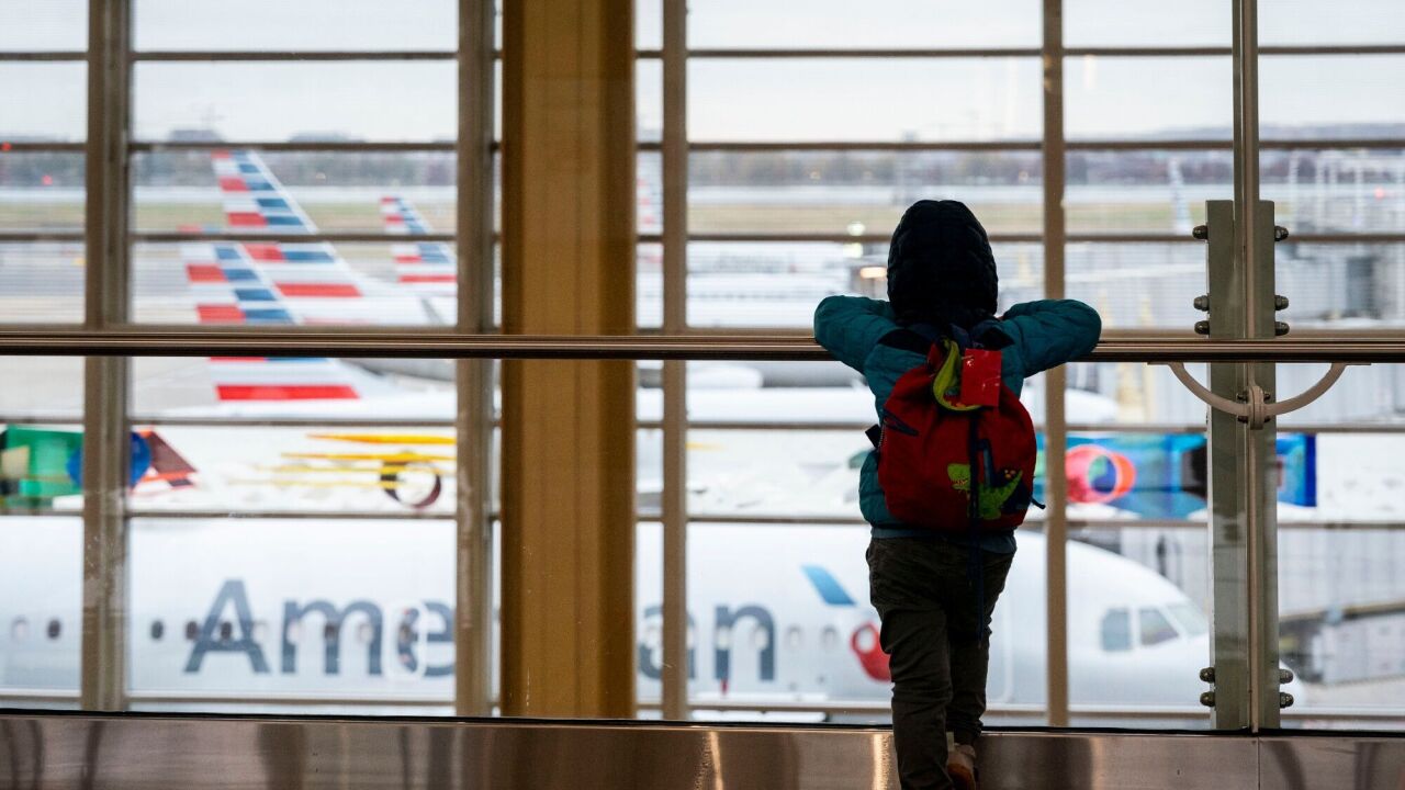 Young traveler views airplanes at Reagan National Airport in Arlington, Virginia