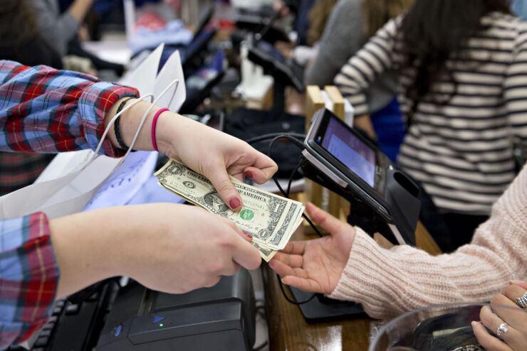 Shoppers exchange payments for retail goods.