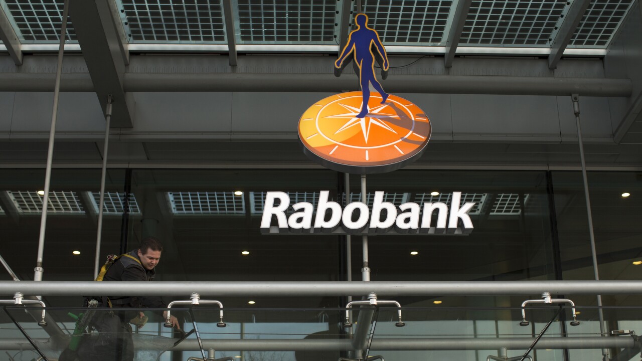 A worker cleans glass awning panels outside the Rabobank headquarter offices in Utrecht, Netherlands.