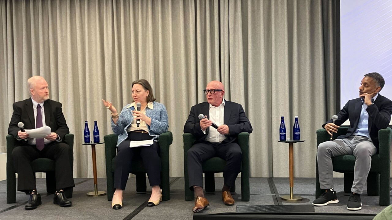Four professionals sit on a panel at an On-Chain event, holding microphones and engaging in a seated discussion.