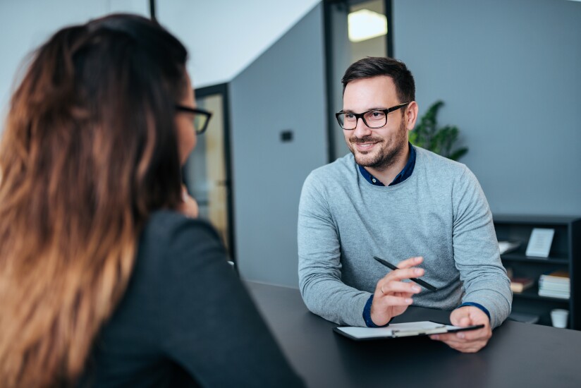 Woman and man sitting across desk having conversation