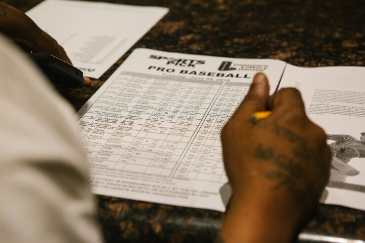 A guest fills out a pick sheet during the launch of full-scale sports betting in Dover, Delaware, U.S., on Tuesday, June 5, 2018.