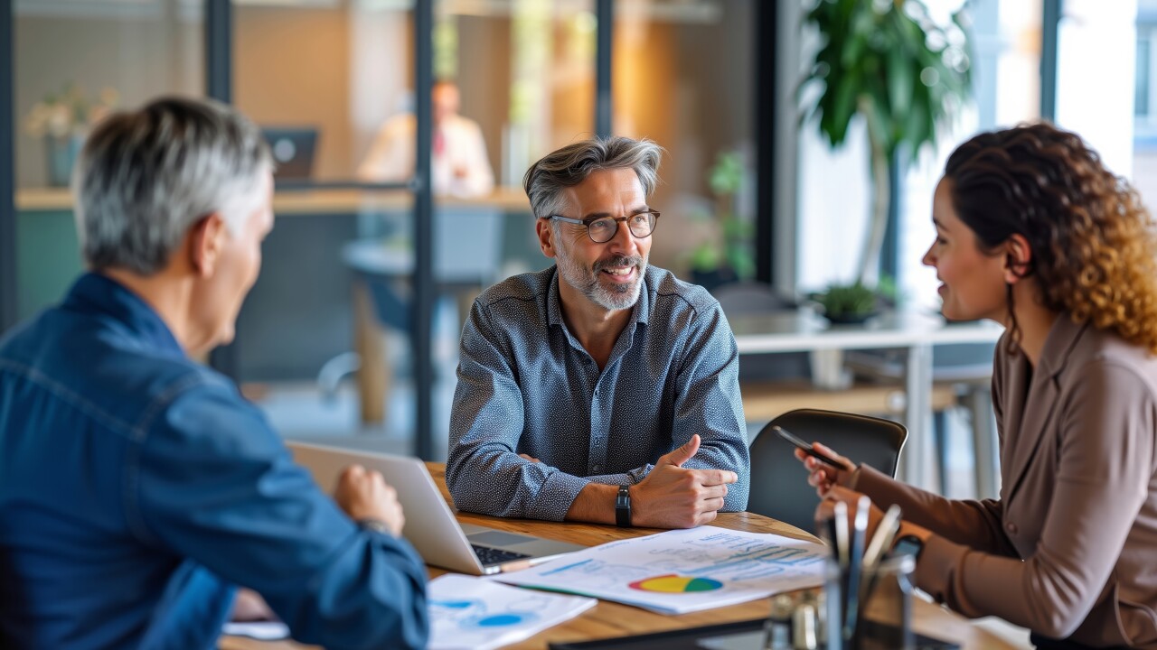 Three people talking at table in office