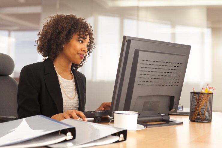 Woman sitting at desk, working on computer