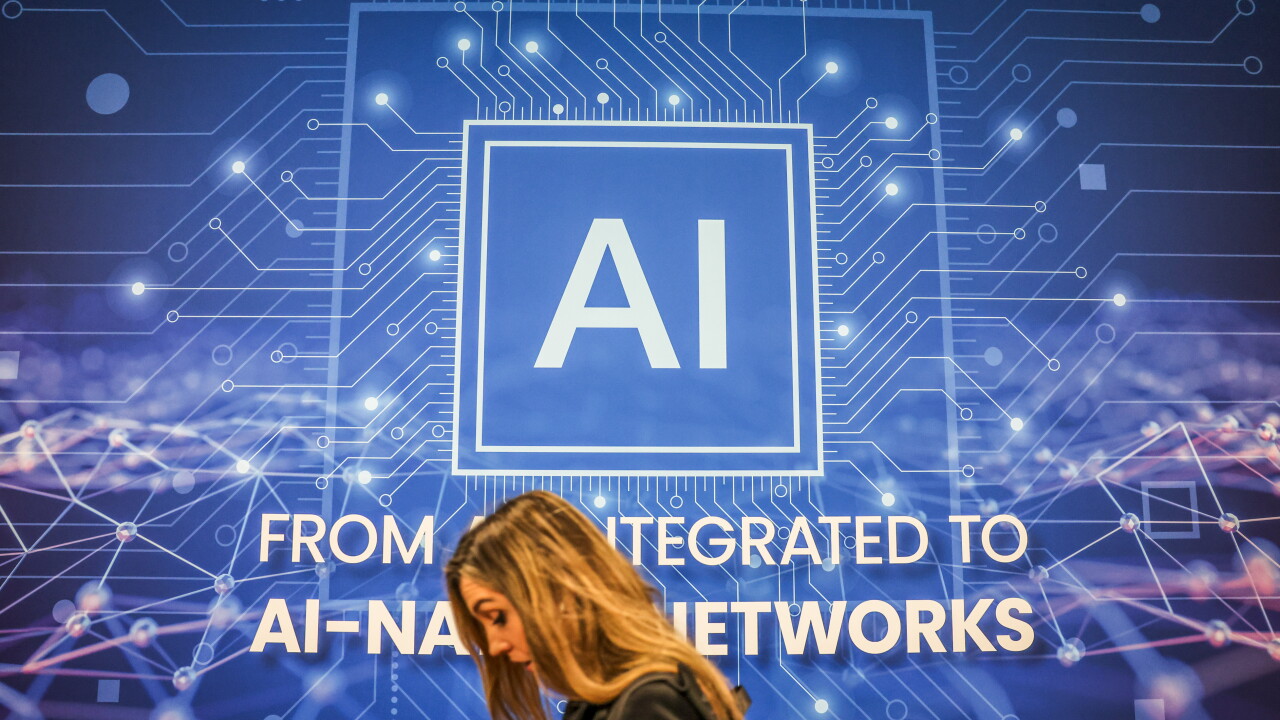 Screen with AI text and woman walking below