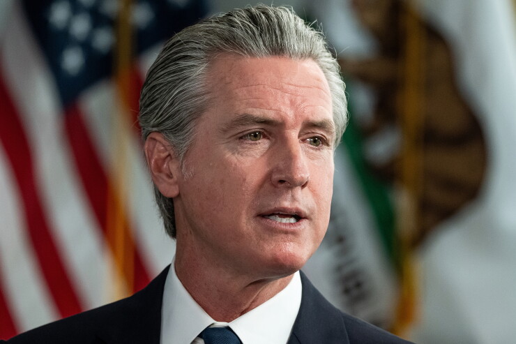 California Governor Gavin Newsom speaking with American flag in background