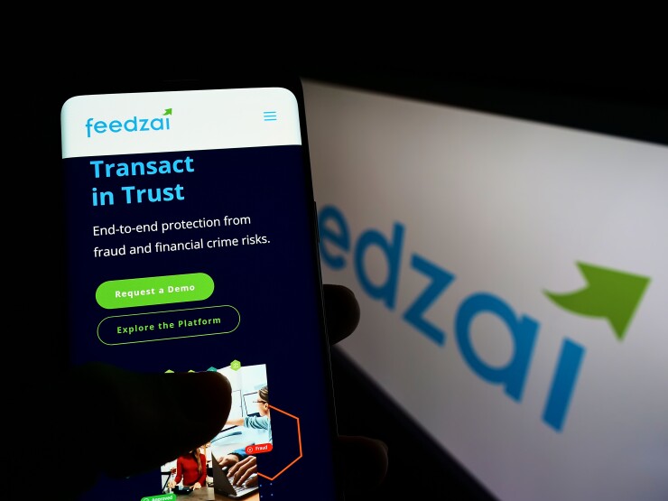 Stuttgart, Germany - 04-03-2022: Person holding smartphone with website of Portuguese risk management company Feedzai on screen in front of logo. Focus on center of phone display.