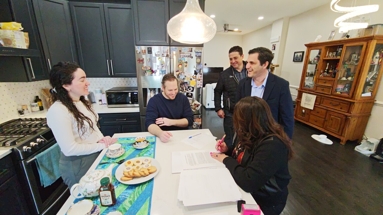 The closing table for the first DREAM transaction for Great Lakes Credit Union and Takara at the McGoverns' house