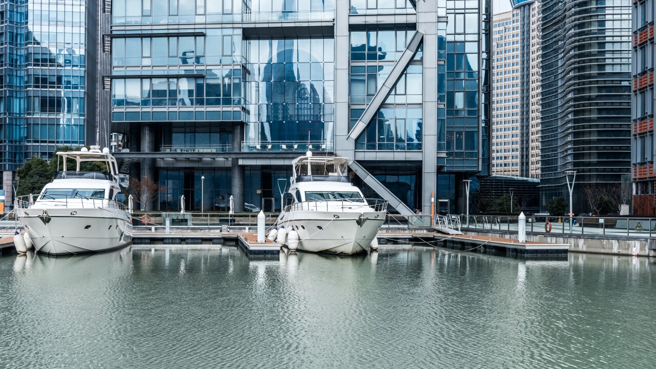 yachts sit along a harbor in a financial district