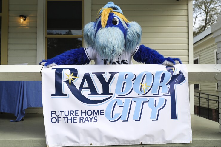 The Tampa Bay Rays baseball mascot, Raymond, displays a banner.