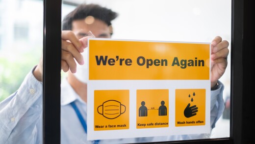 Asian businessman wear face mask attach reopen sign at office af