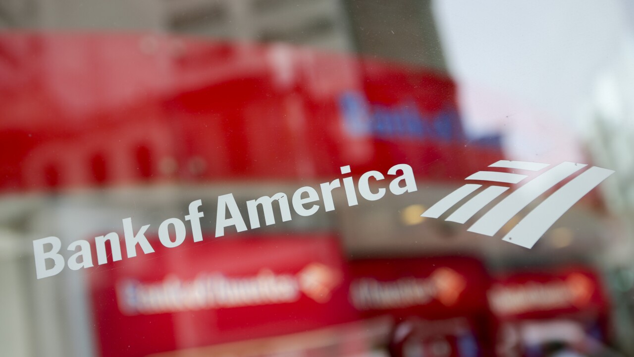 Bank of America sign in white letters on a window of a branch in New York.