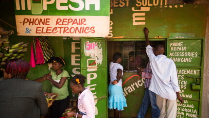 Residents transfer money using M-Pesa at a store in Nairobi, Kenya.