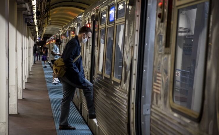 A commuter, wearing a face mask, boards a Chicago Transit Authority (CTA) train in Chicago on Wednesday, June 3, 2020.