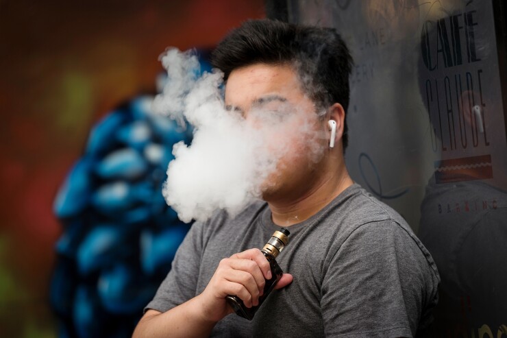 A person exhales vapor while using an electronic cigarette device in San Francisco.