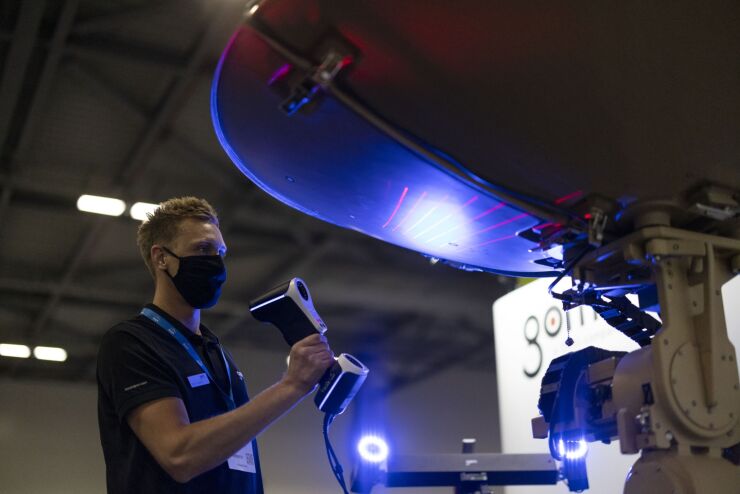 An exhibitor scans a satellite with a T-SCAN hawk hand-held, twin scanner at the Space-Comm Expo in Farnborough, U.K., on Wednesday, July 7, 2021. The new trade exhibition focused on the commercial future of space for business, defence and aerospace, runs until July 8, according to the show's website. Photographer: Jason Alden/Bloomberg