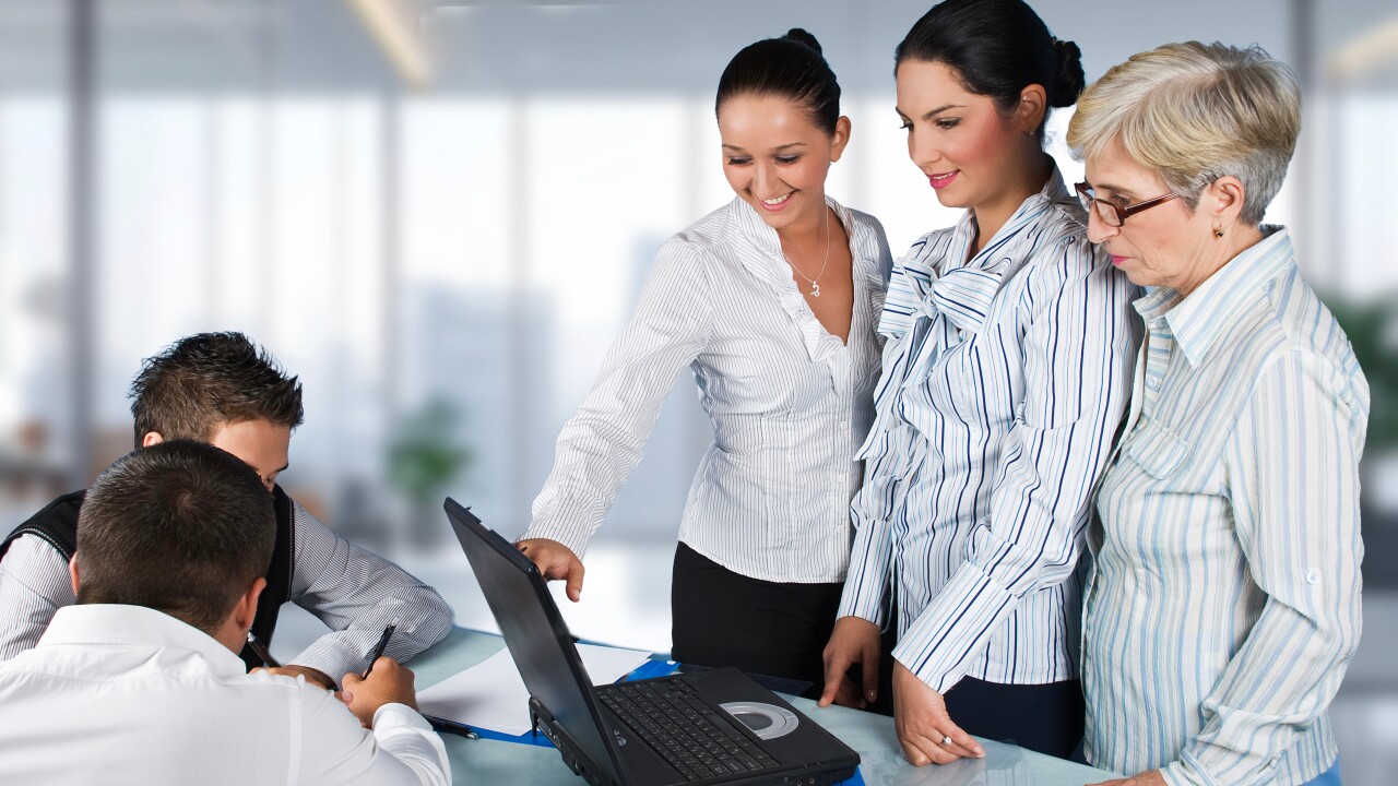 Group of employees, women standing, men sitting