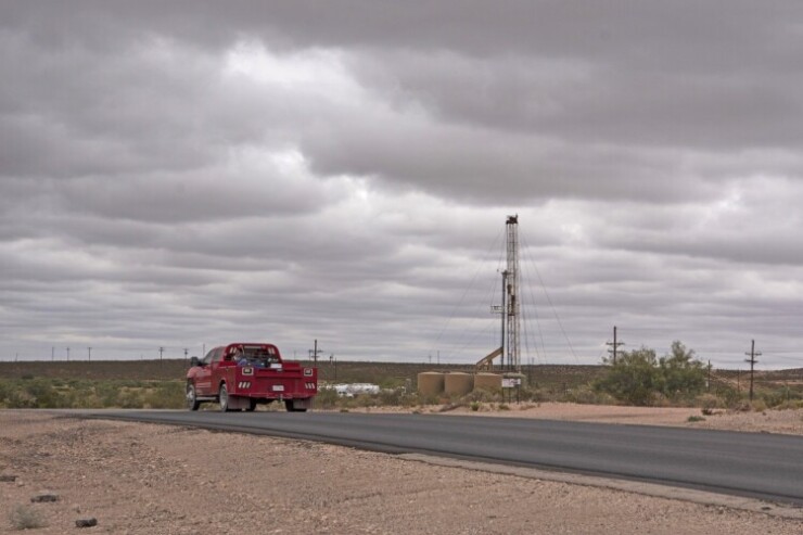 A truck passes a horizontal drilling rig in Lea County, New Mexico.
