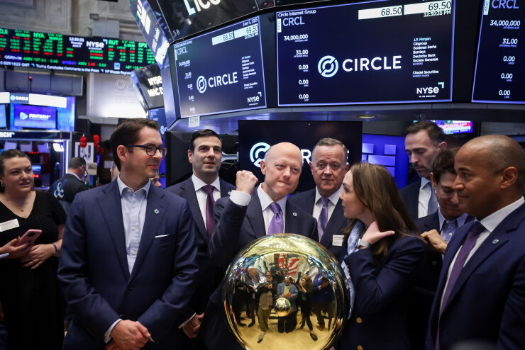 Executives in suits gather around a gold podium on the NYSE floor beneath screens showing the Circle stock logo.