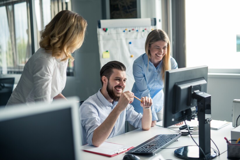Employees gathered around a computer