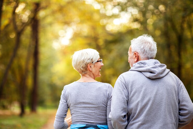 Two older people walking together, smiling