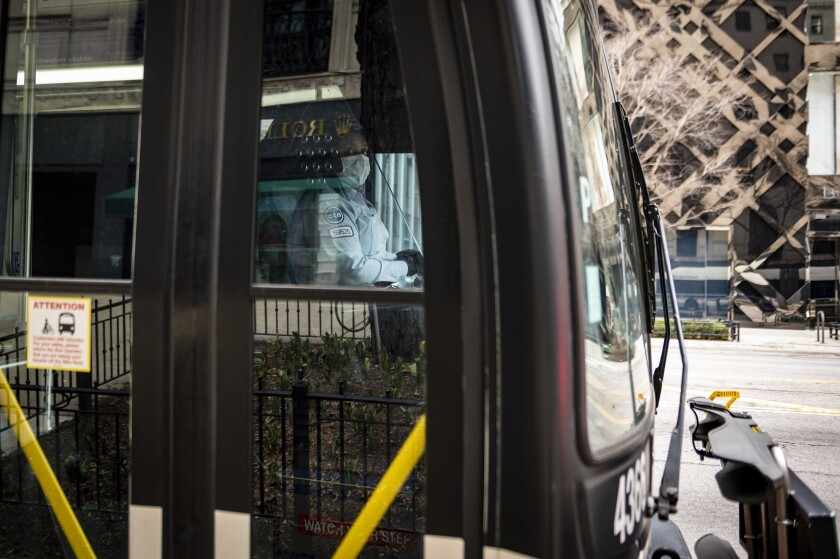 A Chicago Transit Authority (CTA) bus driver wears a protective mask