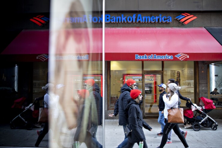Pedestrians walk past a Bank of America branch.