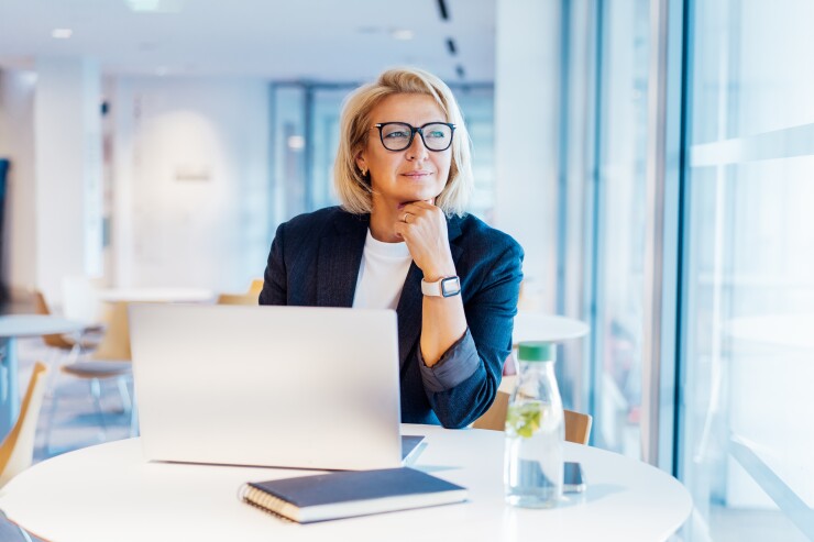 Woman sitting at computer looking out the window