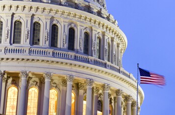 A close up of the capital building with an American flag