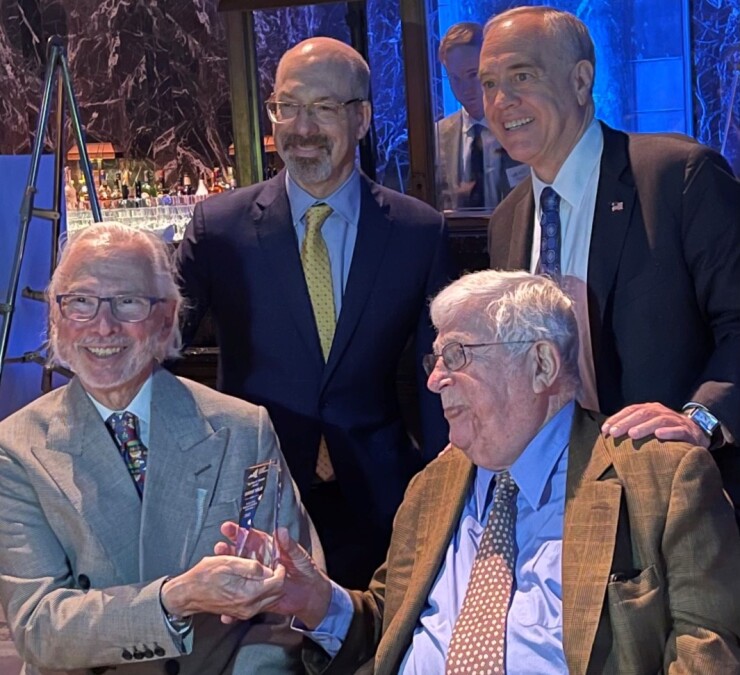 Richard Ravitch, seated right, hands the Citizens Budget Commission's Felix Rohatyn Award to Eugene Keilin at a dinner in June 2022 as CBC head Andrew Rein and NYS Comptroller Thomas DiNaopli look on.