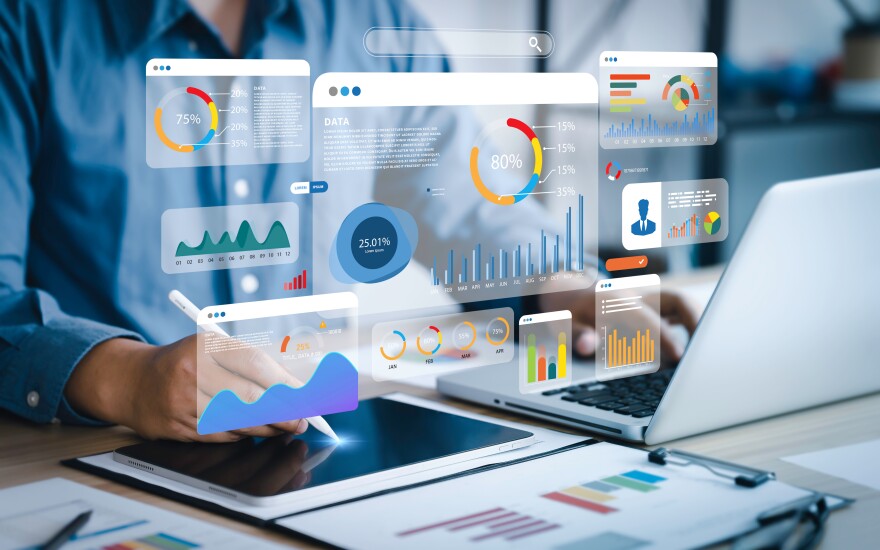 Several infographics and charts superimposed over a person using a tablet and a laptop.