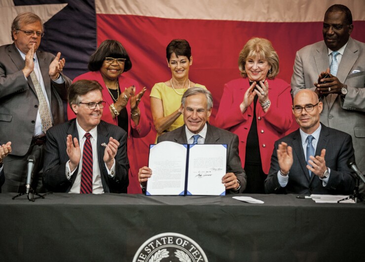 Texas Gov. Greg Abbott, center, at House Bill 3 signing June 11, 2019, with Lt. Gov. Dan Patrick, left, and House Speaker Dennis Bonnen.