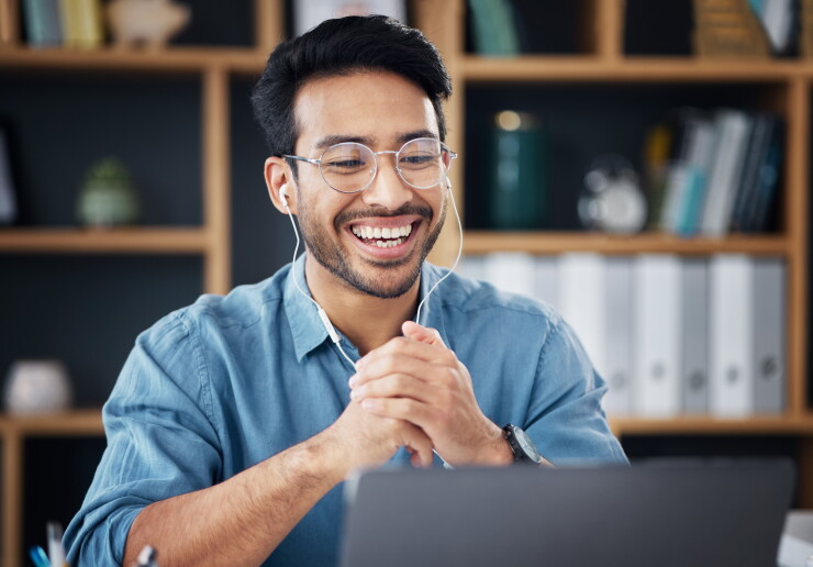 Man on video call, earbuds in, smiling