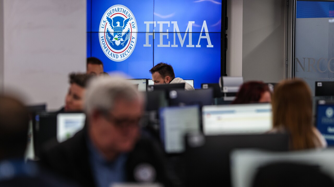 A FEMA sign and people working at the National Response Coordination Center in Washington.