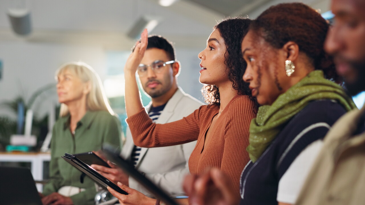 Group of employees, one raising hand