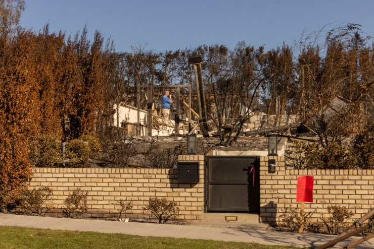 An insurance adjustor inspects an Altadena home razed by the Eaton wildfire.