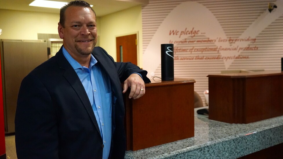 John Merritt, chief information officer at Enrichment Federal Credit Union, poses with one of the Echo Dot devices the CU gave employees to help roll out voice banking via Amazon's Alexa service.