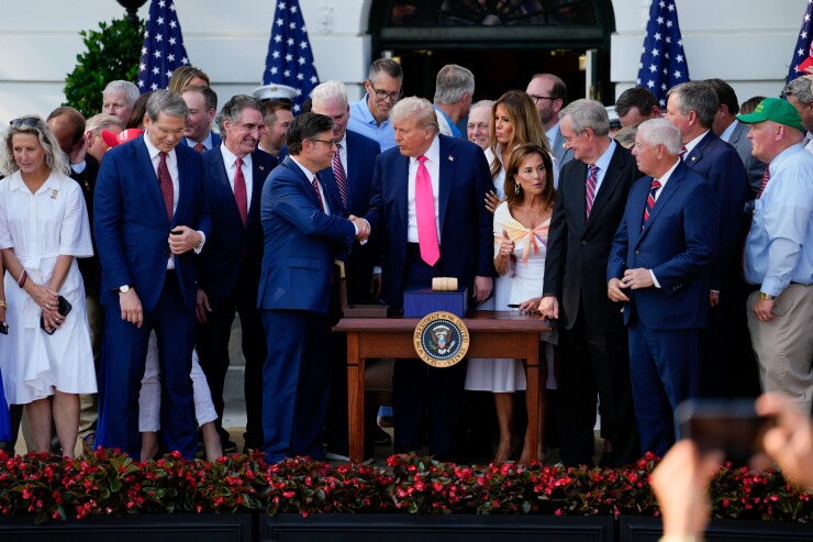 US President Donald Trump and US House Speaker Mike Johnson shake hands after signing the One Big Beautiful Bill Act