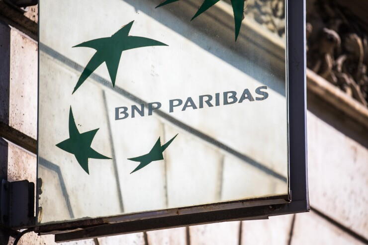 A BNP Paribas logo sits on a sign outside a bank branch in Paris.