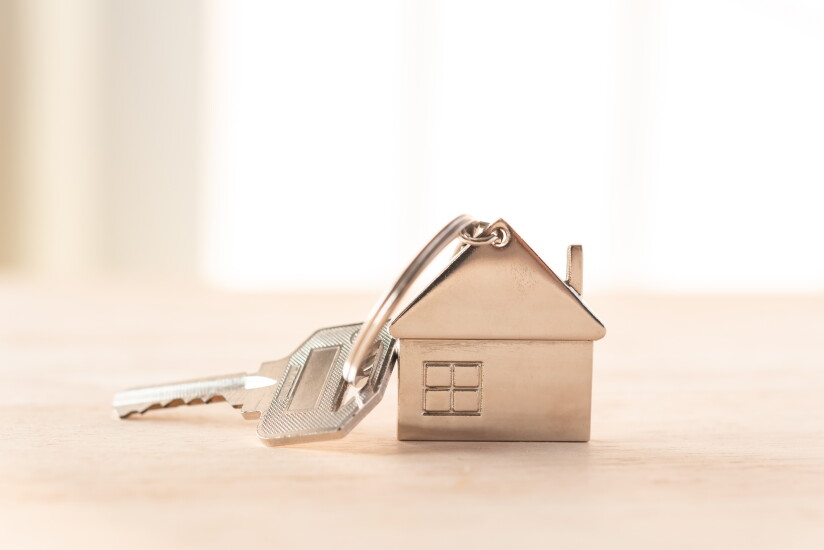 metal key house on wooden table