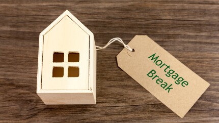 Mortgage Break - Toy wooden house alongside label which reads 'Mortgage Break'