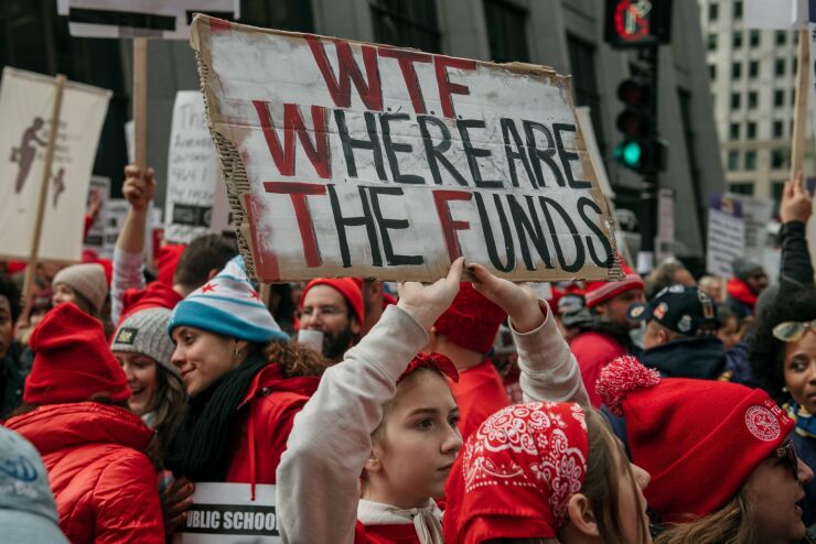 Demonstrators carry signs while marching during a teachers strike in downtown Chicago, Illinois, U.S., on Thursday, Oct. 17, 2019.