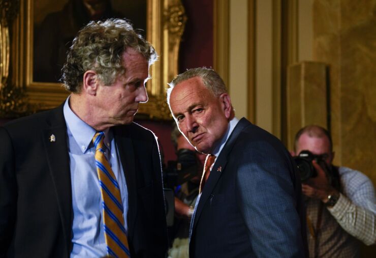 Democrats like Sen. Sherrod Brown of Ohio, left, supported measures such as a temporary ban on overdraft fees. But many consumer protection proposals did not make it in to the final stimulus package negotiated by Senate Minority Leader Chuck Schumer, D-N.Y.