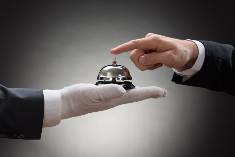 Image representing high-end customer service, with a gloved hand holding a bell.