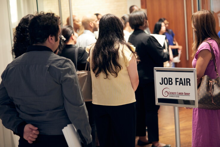 A picture of people standing in line at a jobs fair.